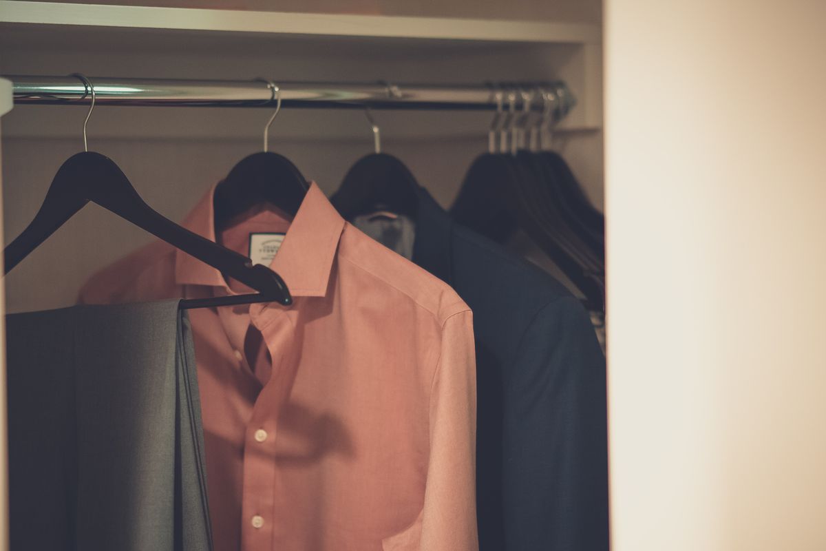 Freshly pressed clothes hanging neatly in a wardrobe